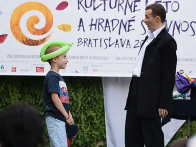 Kúzelník Jaro sa pozerá na chlapca s balónovou čiapkou